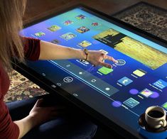 a woman sitting in front of a tablet computer