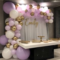 a table topped with lots of balloons next to a white and gold cake stand covered in confetti