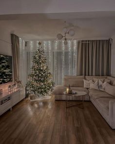 a living room filled with furniture and a christmas tree in front of a large window