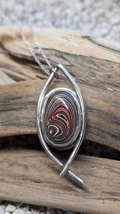 This  Corvette fordite, pre 2010, pendant necklace is handcrafted and set in sterling silver. It also comes with a 20 inch stainless steel chain.   I spend hours designing and handcrafting every pendant. It's very rewarding for me when I start with just sterling silver sheet and wire, and make it into a unique and one of a kind piece of jewelry.  If you would like additional pictures, please let me know and I will take some more. What is Fordite? Here's the story behind it. Years ago at a Ford plant, as the cars were painted, the overspray would build up on the racks and shelves in the paint booth. Eventually it was removed and a some employees brought some of that home and polished it up in much smaller pieces. Then others discovered it and started started creating things with it. That's Hebrew Jewelry, Fordite Jewelry, Leland Blue Stone, Blue Stone Pendant, Paint Booth, Pendant Ideas, Metalwork Jewelry, Fused Glass Jewelry, Motor City