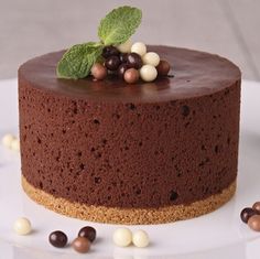 there is a chocolate cake with white and brown candies around it