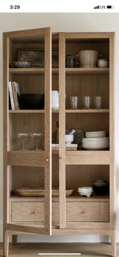 a wooden cabinet with glass doors and dishes on it