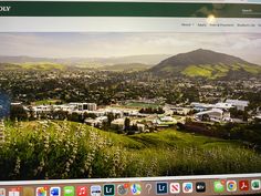 a computer screen with the image of a city on it's monitor and mountains in the background