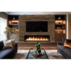 a living room with two couches and a fire place in the wall behind it