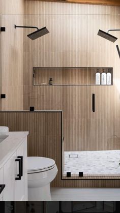 a bathroom with wooden paneling and white fixtures