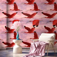 a room with pink wallpaper and red birds on the wall, along with a white chair