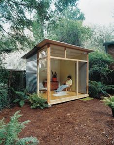 a person sitting in a small wooden shed