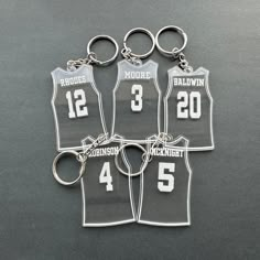 four basketball jersey keychains with numbers on them