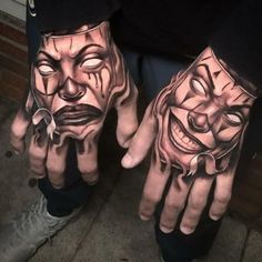 two hands that have tattoos on them with faces painted on the palms and one is wearing a mask