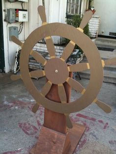 a wooden ship's wheel on display in front of a building