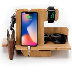 an iphone charging station with sunglasses, cell phone and other items on it's stand