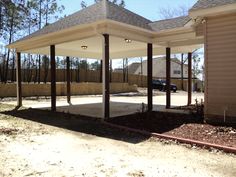 an empty covered parking lot in front of a house