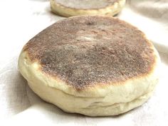 two round breads sitting on top of a white cloth