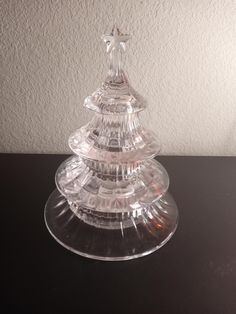 a clear glass christmas tree sitting on top of a table