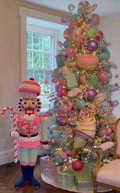 a decorated christmas tree in the corner of a living room with a large nutcracker standing next to it