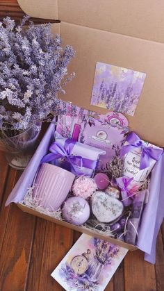 a box filled with lots of different items next to a vase full of lavender flowers