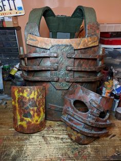 an old, rusted metal armor sits on a wooden table next to other items