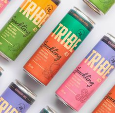 several cans of fruit tea are lined up in a row on a white surface with the words tribe printed on them