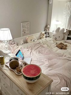 a watermelon bowl sitting on top of a bed next to a laptop computer