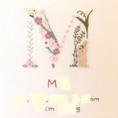 a cross stitch pattern with flowers and the word mom written in cursive writing