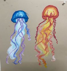 two jellyfishs are drawn on a piece of paper with colored crayons