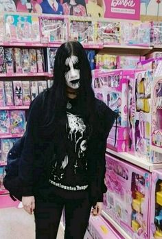 a person with makeup on their face standing in front of shelves filled with toys and dolls