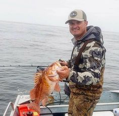 a man on a boat holding a fish