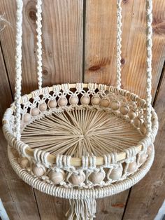 a macrame basket hanging on a wooden wall