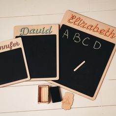 two blackboards with writing on them next to some pencils and an eraser