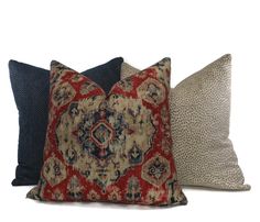 three pillows with different patterns on them, one in red and the other in blue