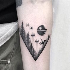 a star wars themed tattoo on the left inner arm and shoulder, with trees in the foreground