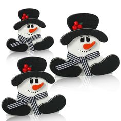 three snowmen wearing black hats and scarfs