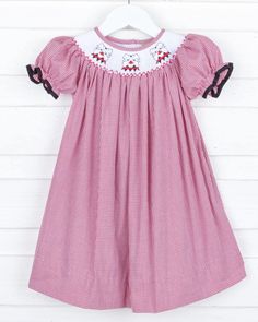 Go dawgs! Cheer on Georgia in our adorable Georgia Smocked Bishop Dress. Features Georgia's bulldog mascot smocked across the neckline. Cute bishop sleeves on a red gingham. Perfect for football season! Gameday | kids | outfits | kids trends | tremding | kids inspiration | kids style | kids closet | what to wear | fall inspo | fall | football | football season | college football | amocked | smocked outfits | kids clothing Smocked Baby Clothes, Red Gingham Dress, Smocked Bishop Dress, Girls Applique, Santa Face, Gingham Fabric, Dress Drawing, Game Dresses, Football Outfits