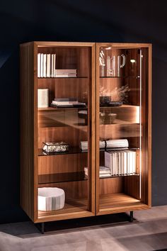 a wooden book case with glass doors and shelves filled with books on top of each shelf