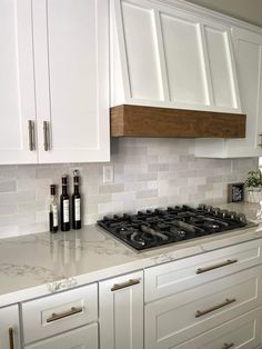 a stove top oven sitting inside of a kitchen next to white cabinets and counter tops