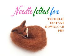 the needle felt fox is laying down on top of it's own fur ball