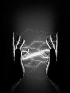 two hands reaching out towards each other in the dark with bright lightening behind them