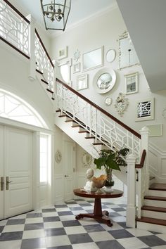 there is a vase with flowers on the table under the stairs