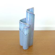 two blue vases sitting on top of a wooden table