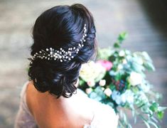 a woman wearing a bridal hair comb with flowers in the background