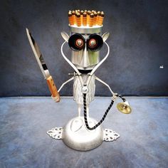 a metal robot with many bottles on it's head and two knives in his hand