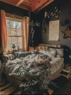 an unmade bed sitting next to a window in a bedroom