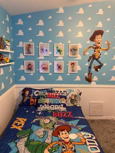 a bed room with a neatly made bed and toy story wallpapers on the walls