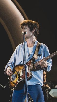 a man with a guitar on stage at a concert