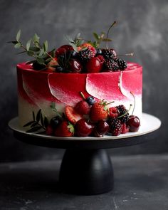 a red cake with berries and blackberries on top