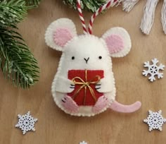 a white mouse ornament hanging from a christmas tree