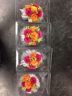 four plastic containers with flowers in them on a table