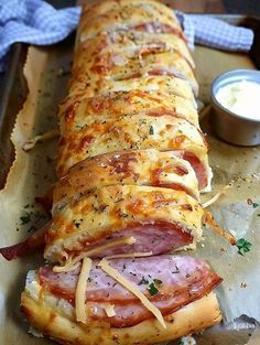 a ham and cheese bread is on a baking sheet