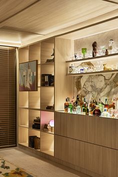 a room with shelves filled with bottles and glasses on top of each shelf next to a rug