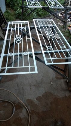 two metal tables sitting on top of a dirt ground